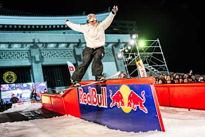Grace Warner delivers an epic rail slide at Red Bull Cow Day 2024 in Osaka, showcasing her skills against a vivid backdrop.