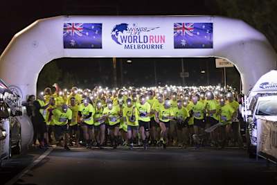Runners with headlights on for the wings for life world run in Melbourne.