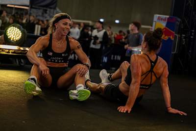Megan Jacoby and Lauren Weeks share a moment during the Elite 15 at the Hyrox Major event in Amsterdam, Netherlands, showcasing strength and sportsmanship in 2024.
