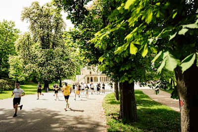 Os participantes correm em meio a uma vegetação exuberante na Red Bull Wings for Life World Run 2025 em Praga, que mostra a combinação única de comunidade e compromisso desse evento global