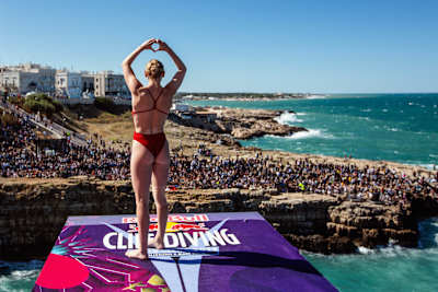 Molly Carlson sends some love to the crowd in Polignano a Mare, Italy, during the Red Bull Cliff Diving World Series.