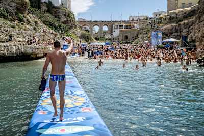 Oleksiy Prygorov aus der Ukraine winkt nach dem Sprung in Polignano a Mare, Italien, der Menge zu.