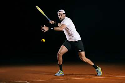 Matteo Berrettini se prepara en una pista de tierra batida de Milán, Italia, para una enérgica sesión fotográfica el 4 de febrero de 2023, encarnando el emocionante espíritu de la marca.