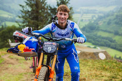 Rónán Dunne pushes his mountain bike at the 2025 Red Bull Hardline in Dyfi Valley, Dinas Mawddwy, Wales.