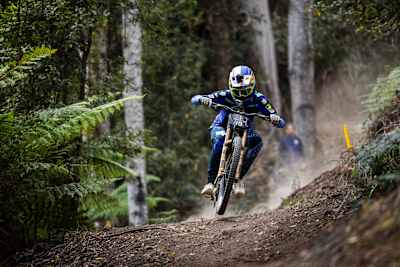 Asa Vermette charges downhill through the rugged trails of Red Bull Hardline 2025 at Maydena Bike Park, Tasmania, showcasing intense speed and Red Bull's unstoppable spirit.
