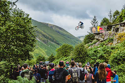 Asa Vermette catches massive air at Red Bull Hardline 2025 in Dinas Mawddwy, Wales, thrilling the crowd against a backdrop of dramatic mountain scenery.