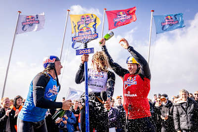 Lorenzo Casati, Andrea Principi en Cohan van Dijk vieren de overwinning bij de Red Bull Megaloop 2025 in Noordwijk, Nederland, met wapperende vlaggen en champagne spuitend op 15 september