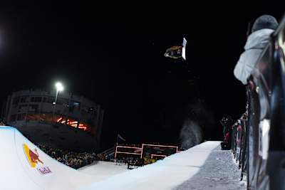 On January 17, 2026, Scotty James catches air in the halfpipe at the Laax Open in Laax, Switzerland, with crowds and cameras capturing the dynamic moment.