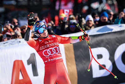Swiss skier Marco Odermatt celebrates second place at the 2026 Hahnenkamm Race in Kitzbühel, Austria in front of crowds in a packed finish area.