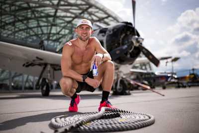 Jake Dearden aus Großbritannien feiert am 8. Mai 2026 im Red Bull Hangar-7 in Salzburg, Österreich, das Ziehen des 3,8 Tonnen schweren nordamerikanischen Flugzeugs T-28B.