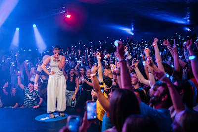 Demi Moran performs among an ecstatic crowd at the Red Bull Dance Your Style Final in Dublin, Ireland, on 18 July 2026, under vibrant blue and red stage lights