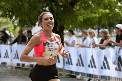 Imke Salander läuft am 10. Mai 2026 beim Wings for Life World Run durch München, angefeuert von Zuschauern hinter den adidas-Absperrungen