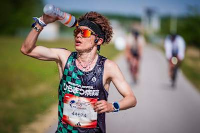 Jo Fukuda running and hydrating during the Wings for Life World Run 2024 in Vienna, Austria