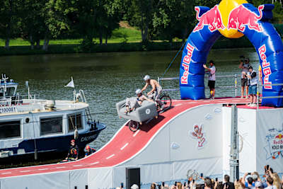 Davy ľudí jasajú, keď odvážny tím spúšťa svoje kreatívne vozidlo z rampy na podujatí Red Bull Kolo Molo 2025 v Prahe, ktoré zachytáva podstatu dobrodružstva a vzrušenia