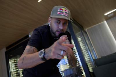 Neymar da Silva Santos Júnior fala para a câmara enquanto segura um microfone. 