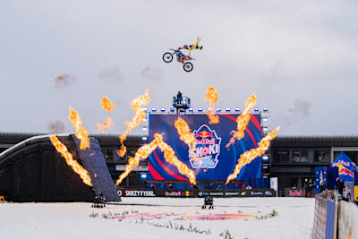 A freestyle motocross rider launches skyward surrounded by fire at Red Bull Target Jumping in Zakopane, Poland, in April 2025