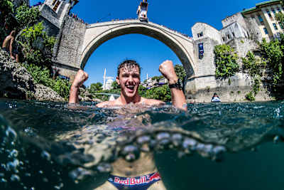 Aidan Heslop celebrates a successful dive off Stari Most in Mostar during the Red Bull Cliff Diving World Series in 2023