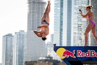 Molly Carslon (CAN) captures Aidan Heslop (GBR) as he performs a dive from teh 27-metre platform at the Red Bull Cliff Diving World Series in 2024