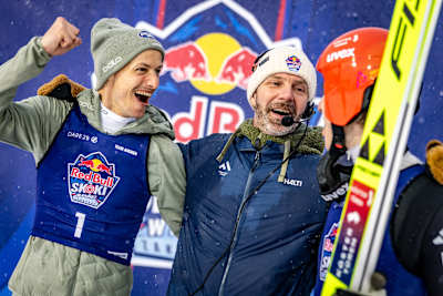 Janne Ahonen and his team show excitement at Red Bull Target Jumping 2026 in Zakopane, Poland, as snow falls during the April ski jumping event.