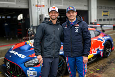 Max Verstappen und Arda Saatci posieren mit dem markanten Red Bull AMG-Rennwagen während der Saison 2026 auf dem Nürburgring, der den dynamischen Rennsportgeist von Red Bull verkörpert