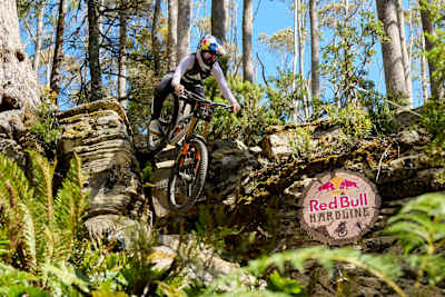 Gracey Hemstreet nimmt beim Training zur Red Bull Hardline 2026 im australischen Maydena Bike Park eine technische Abfahrt in Angriff, umgeben von schroffen Felsen und wilden tasmanischen Wäldern.