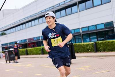 Yuki Tsunoda is captured running at the Wings for Life World Run held at Red Bull Racing in Milton Keynes, May 2026, showcasing high-energy Red Bull spirit