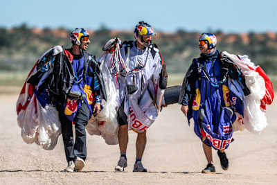 Marco Waltenspiel, Peter Salzmann and Marco Fürst walk after landing at the Red Bull Aerial Performance Camp 