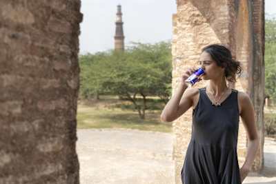 Na zdjęciu widać Tanię Sachdev na tle Qutab Minar w Delhi w Indiach.