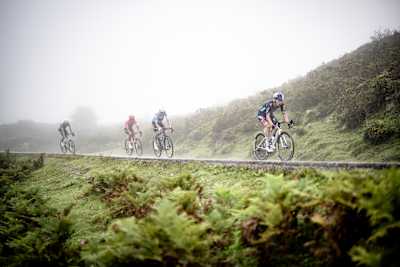 Primož Roglič of Red Bull - BORA - hansgrohe leads Enric Mas and Richard Carapaz up the misty Covadonga climb during La Vuelta 2024 in Spain