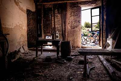 Wout van Aert, wearing the green points leader jersey for Visma-Lease a Bike, passes a the doorway of a derelict house during Stage 12 of La Vuelta 2024 in Spain.