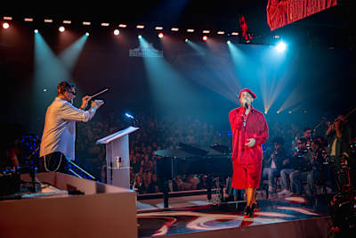 MC Hariel performs with conductor Xuxa Levy during Red Bull Symphonic in São Paulo, Brazil, on 8 August 2026, backed by a live orchestra and grand piano.