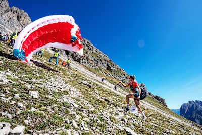 Aaron Durogati launches his paraglider on a rugged mountain slope during Red Bull Dolomitenmann 2026 in Lienz, Austria.