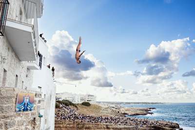 In 2026, Italy’s Andrea Barnaba launches from a 26-metre balcony during the first round of the fifth and final Red Bull Cliff Diving World Series stop in Polignano a Mare