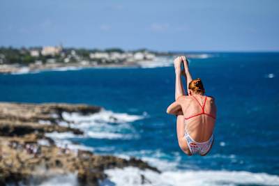 Molly Carlson of Canada launches from the 22-metre platform during the 2026 Red Bull Cliff Diving World Series final stop in Polignano a Mare, Italy
