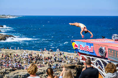 Xantheia Pennisi of Australia performs an armstand dive from the 22-metre platform during the 2026 Red Bull Cliff Diving World Series in Polignano a Mare, Italy
