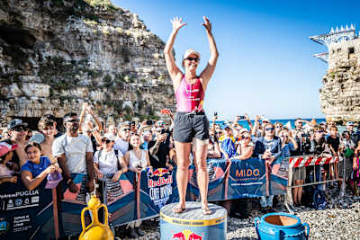Rhiannan Iffland of Australia celebrates her 2026 Red Bull Cliff Diving World Series victory in Polignano a Mare, Italy, surrounded by cheering fans after claiming the King Kahekili trophy