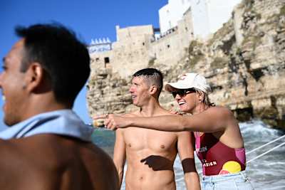 Rhiannan Iffland shows Oleksiy Prygorov the result during the 2026 Red Bull Cliff Diving World Series final in Polignano a Mare, Italy