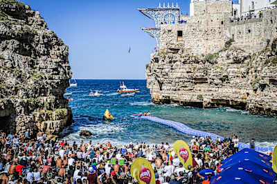Sergio Guzman of Mexico dives from the 27-metre platform during the 2026 Red Bull Cliff Diving World Series final in Polignano a Mare, Italy, watched by a packed crowd