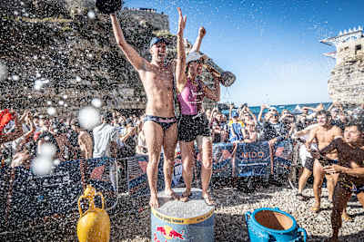 Aidan Heslop and Rhiannan Iffland celebrate winning the 2026 Red Bull Cliff Diving World Series King Kahekili trophy in Polignano a Mare, Italy, amid a jubilant crowd