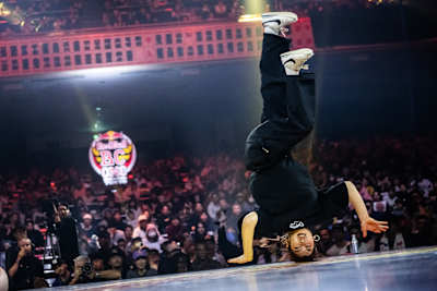 B-Girl Riko of Japan performs an explosive headstand during the 2025 Red Bull BC One World Final at Ryogoku Kokugikan Sumo Arena in Tokyo