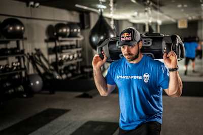On 21 May 2026, Luka Djukic carries a weighted sandbag through a gym in Tivat, Montenegro.