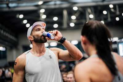 Alexander Rončević drinks Red Bull during Red Bull Hyrox in Vienna, Austria, on 7 February 2026, with competitors and spectators gathered in the gym