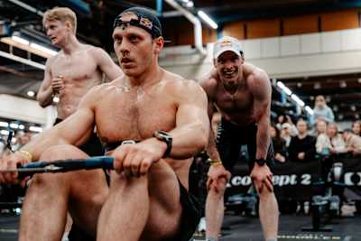 Jonne Koski rows during Hyrox in Helsinki, Finland as Iivo Niskanen takes a well-earned rest after his performance.