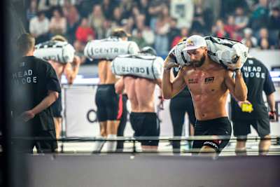 Alexander Rončević carries a heavy sandbag during the 2026 HYROX World Championship in Stockholm, Sweden.