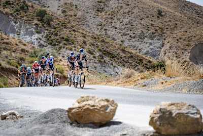 In 2024, polka-dot jersey holder Primož Roglič and Red Bull - BORA - hansgrohe pace the peloton up Puerto de El Purche during Stage 9 of La Vuelta in Spain
