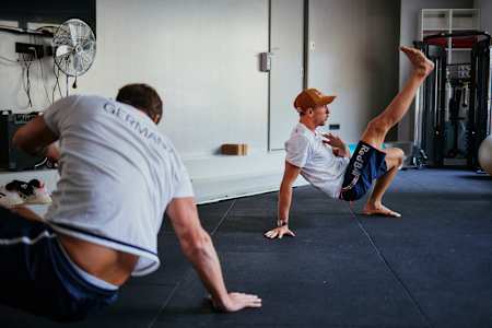 Profi-Surfer Leon Glatzer wärmt sich vor einer Krafttrainings-Session auf.