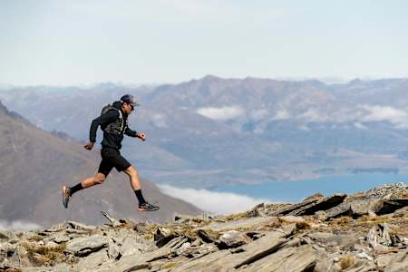 Triathlete Braden Currie runs a trail run in New Zealand with a backpack.