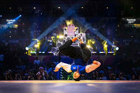 In 2024, B-Girl Nicka performs an acrobatic breakdance move at the Red Bull BC ONE World Final event in Rio de Janeiro, Brazil
