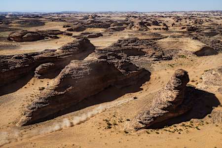 Sébastien Loeb's Prodrive BRX Hunter T1+ racing in Saudi desert during 2024 Dakar Rally.