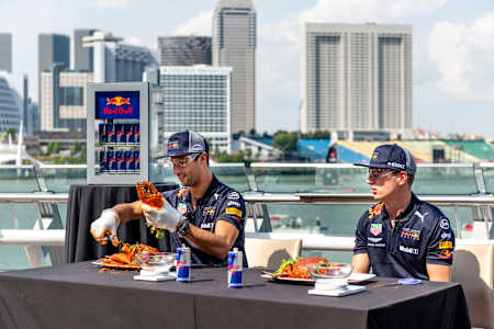 Daniel Riccardo and Max Verstappen attempt to de-shell a crab at a Red Bull event ahead of the Formula One Grand Prix of Singapore in 2018. 